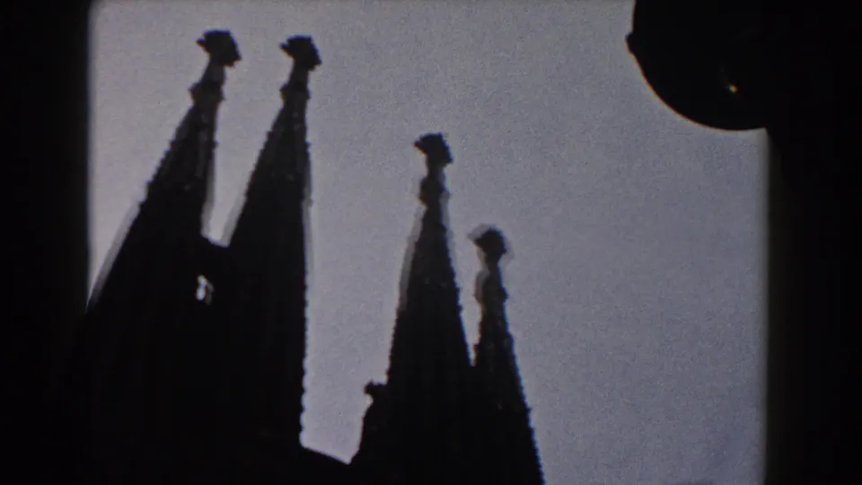 Visitor-shot 1959 Barcelona view of silhouetted church spires, with a street lamp beginning to enter the frame.