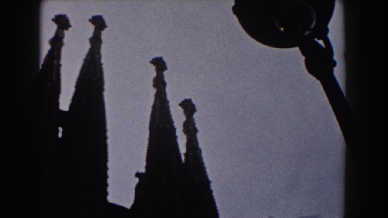 1959 Barcelona 8mm frame showing silhouetted Gothic cathedral spires against a pale sky.