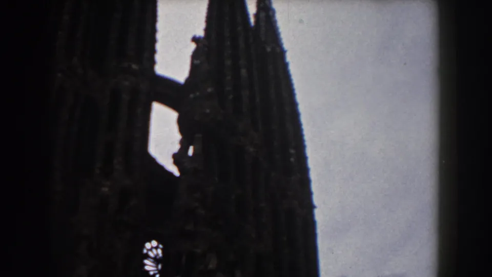 1959 Barcelona view of Sagrada Familia's clustered spires and facade details, filmed in high-contrast 8mm.