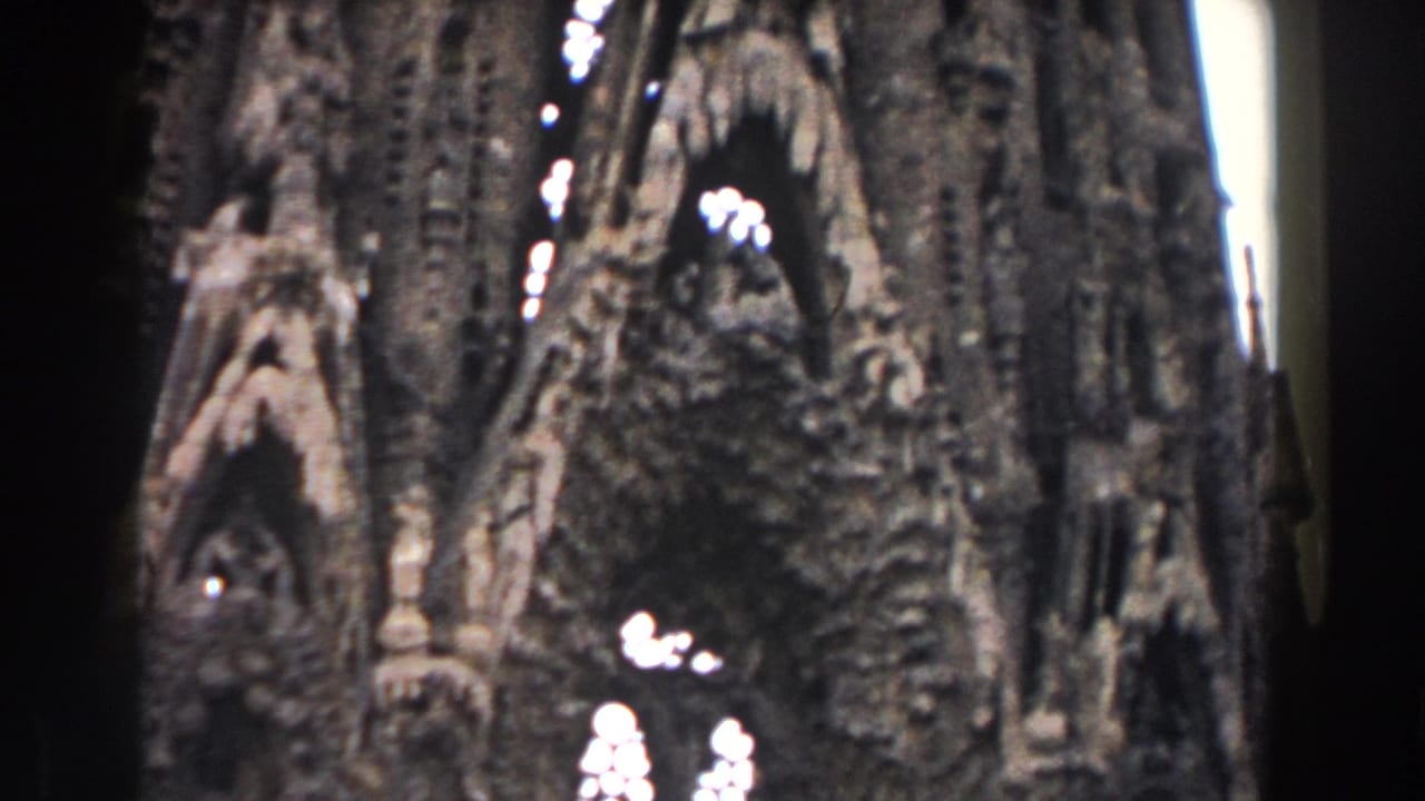 Ornate dark stone cathedral facade with pointed arches and bright window openings.