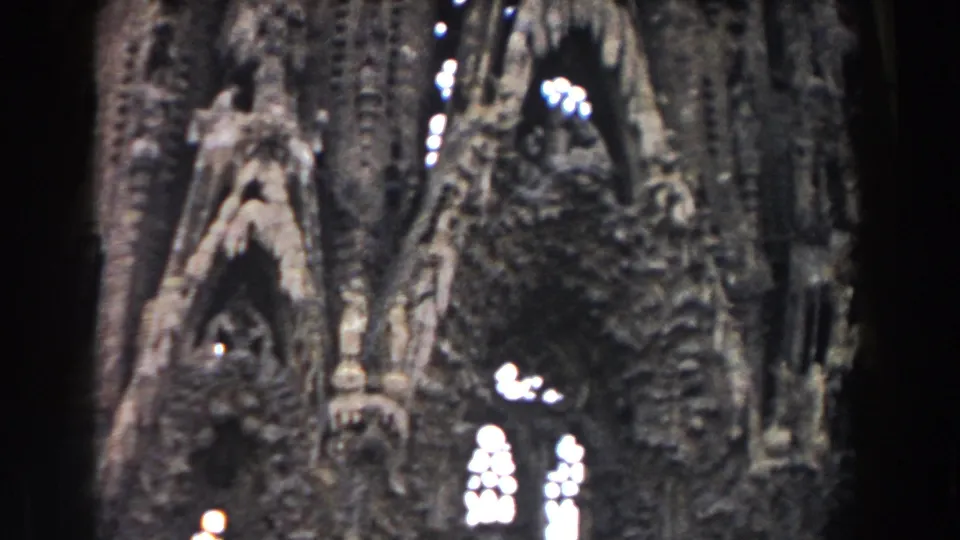 1959 Barcelona frame of a tall cathedral exterior, with sculptural stone detail, pointed arch recesses, and bright stained-glass openings.