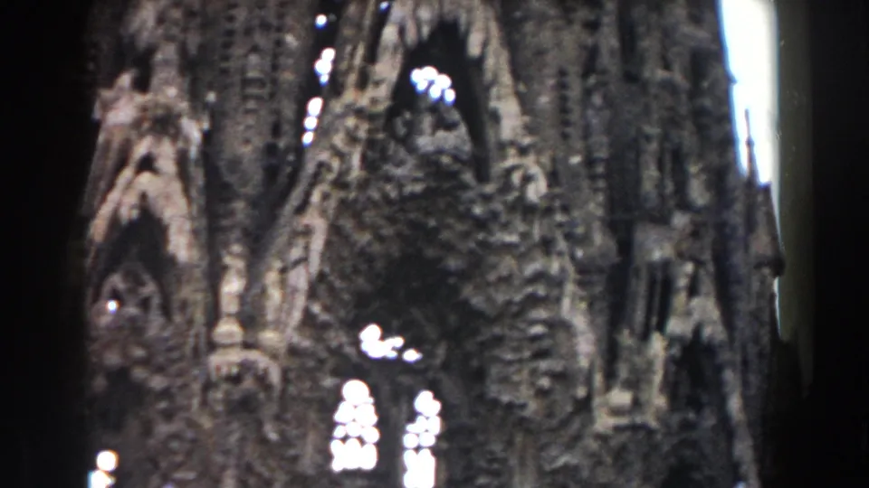 1959 Barcelona frame of the ornate cathedral exterior, showing Gothic-style arches, dense stone ornament, and high-contrast window openings.