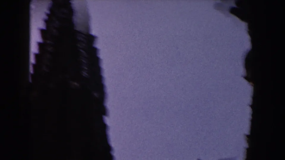 Late-frame 1959 Barcelona view with a blurred tower silhouette and dark edge shadow against a blue-violet sky.