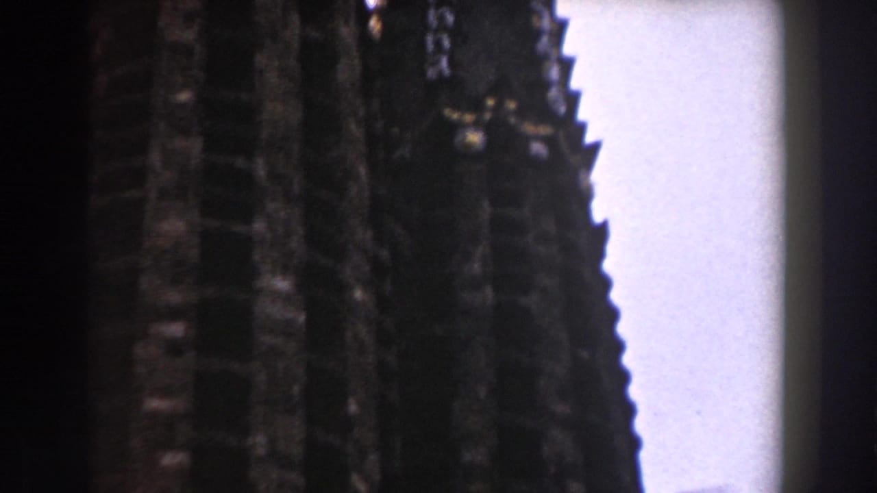 Dark ornate cathedral spires partially silhouetted against a pale sky.