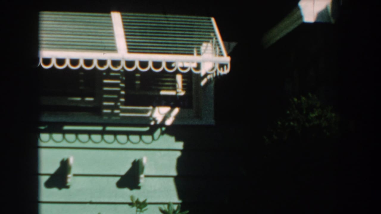Second view of the house window with striped awning and shadows.