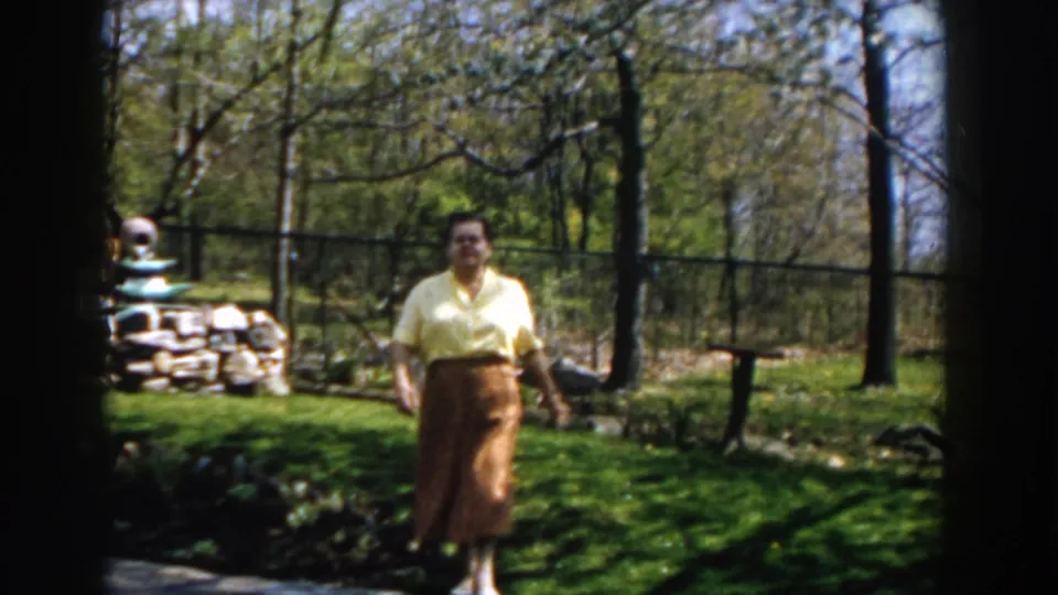 Near the end of the clip, the woman walks close to the camera in the sun-dappled Michigan backyard.