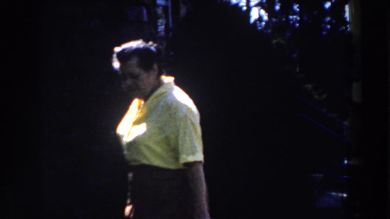 Woman in a yellow shirt walks through deep shade with bright sunlight on her clothing.