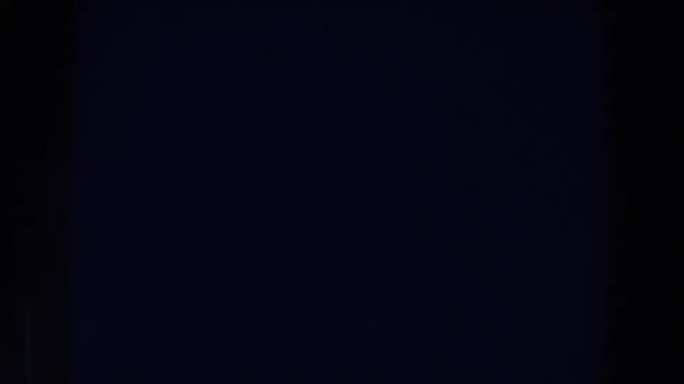 Dark 1959 Michigan 8mm frame with grain, minimal detail, and a faint uneven exposure pattern.