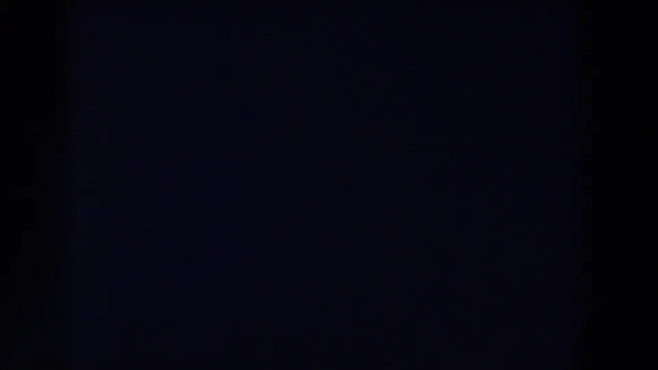 1959 Michigan 8mm frame showing a mostly dark blue-black exposure area, faint red banding near the top, grain, and minimal visible detail.