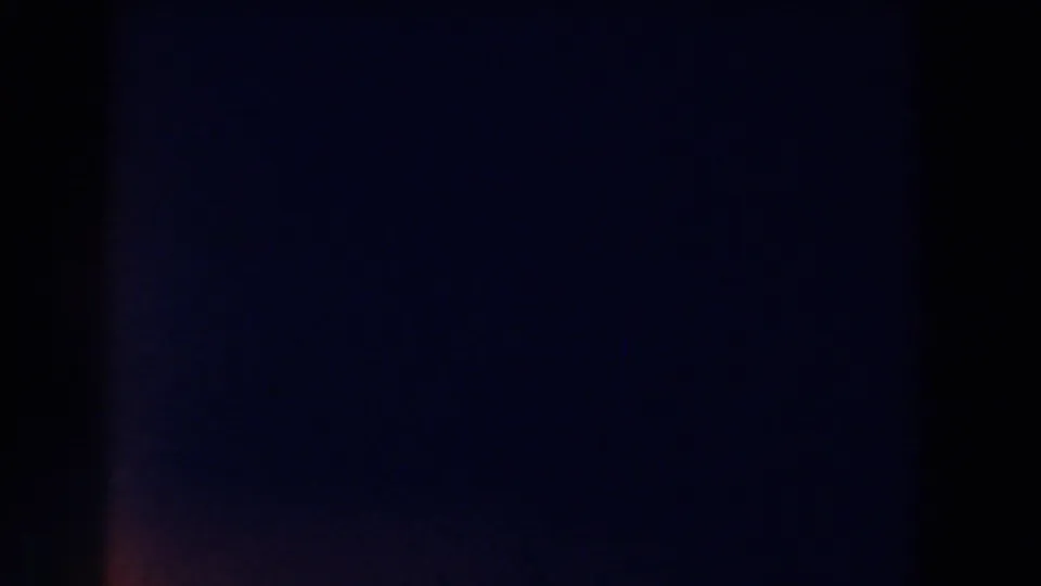 Opening 8mm frame is largely dark with faint purple-blue exposure variation and no clear subject visible.