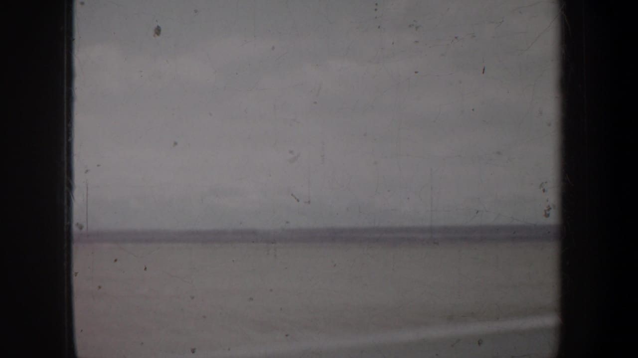 Muted horizon and sky framed by dark vertical film borders.
