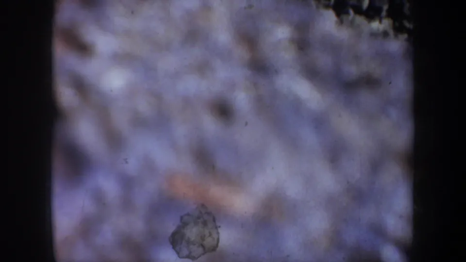 1957 Oregon 8mm frame dominated by soft, pale moving water, with dark film borders and a small rock-like form near the lower edge.