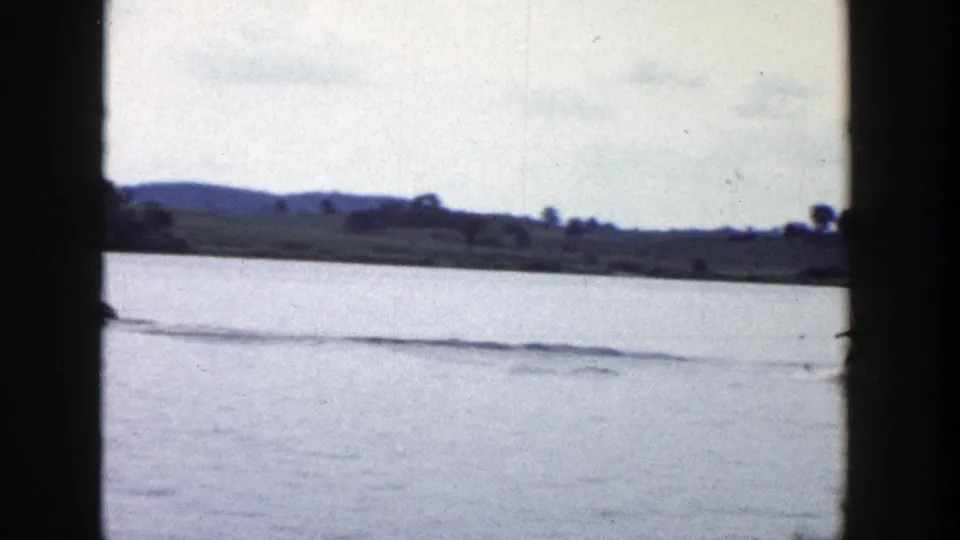 A final 1958 Wisconsin lake frame shows the skier mostly out of view, leaving a long wake across calm water.