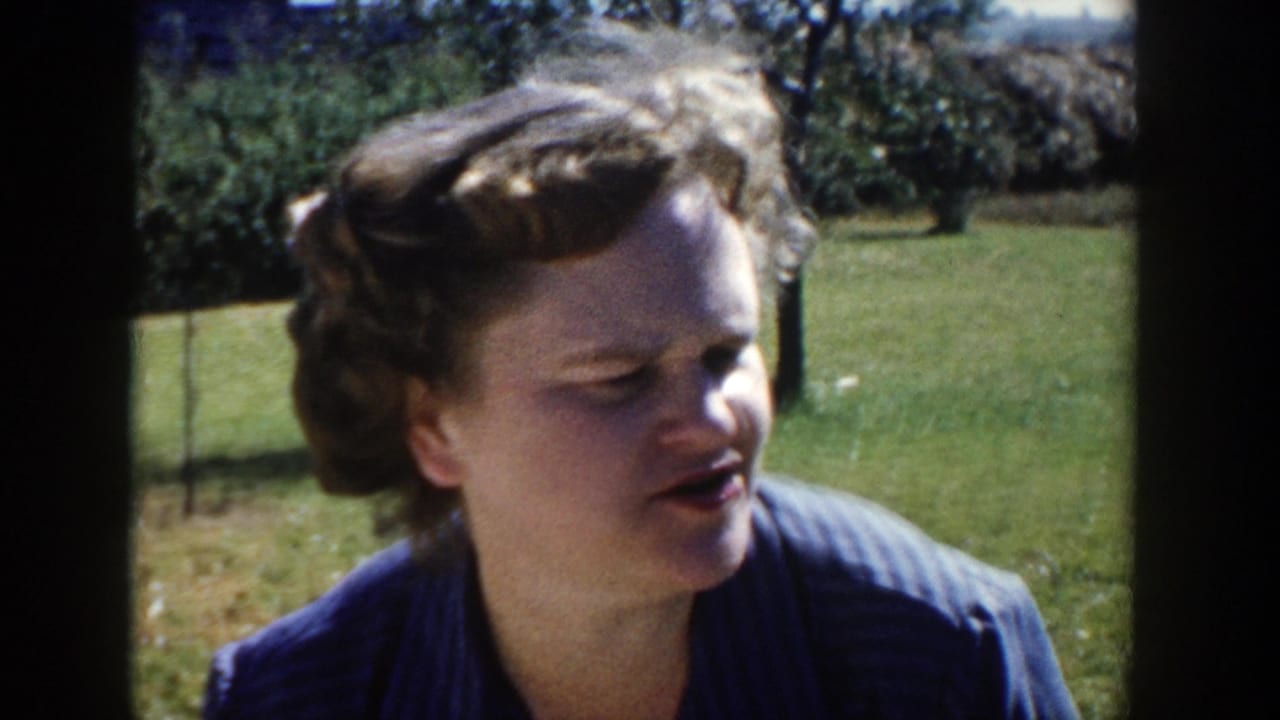 The second woman turns in profile, appearing to speak in the 1958 Wisconsin outdoor home-movie gathering.