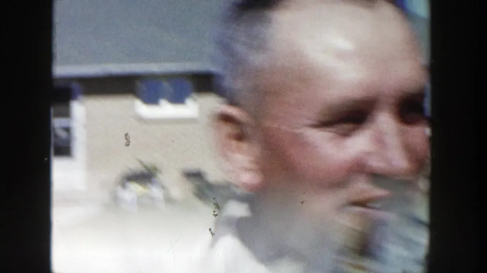 The man appears in soft motion blur while turning in the Wisconsin backyard, with the house and lawn still visible behind him.