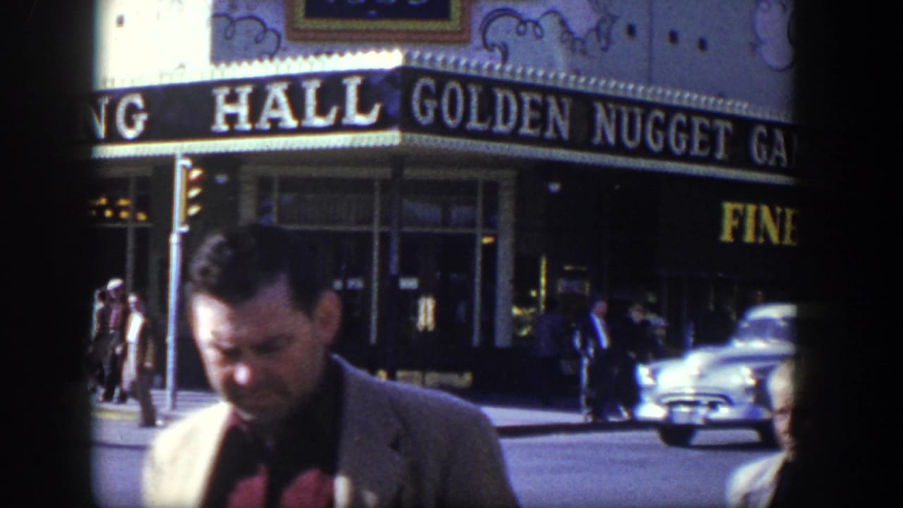 Man in a suit walks past the Golden Nugget Gambling Hall marquee as a car passes in the street.