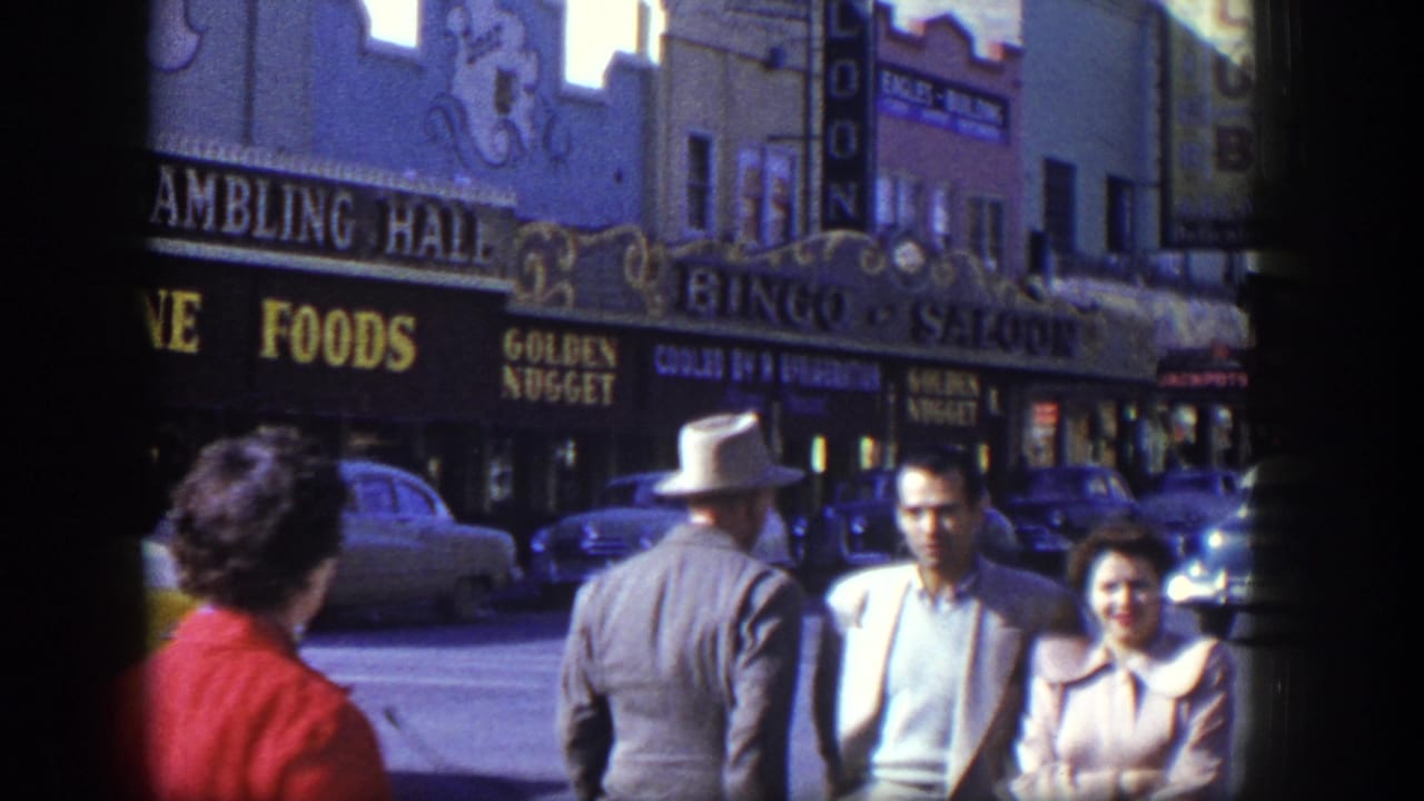 1954 Las Vegas street view with pedestrians, mid-century cars, and signs for Gambling Hall, Fine Foods, and Golden Nugget.