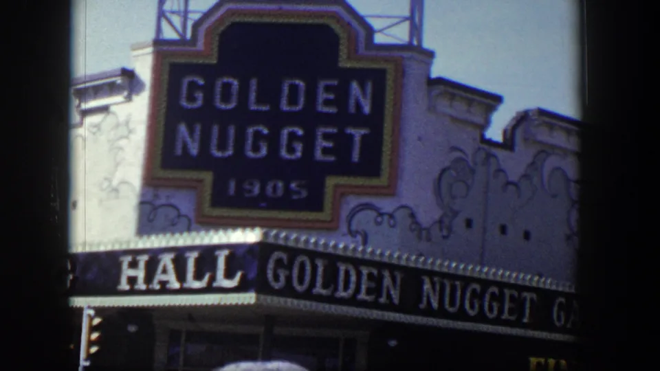 Close 1954 Las Vegas view of the Golden Nugget sign with partial Gambling Hall awning and decorative facade details.