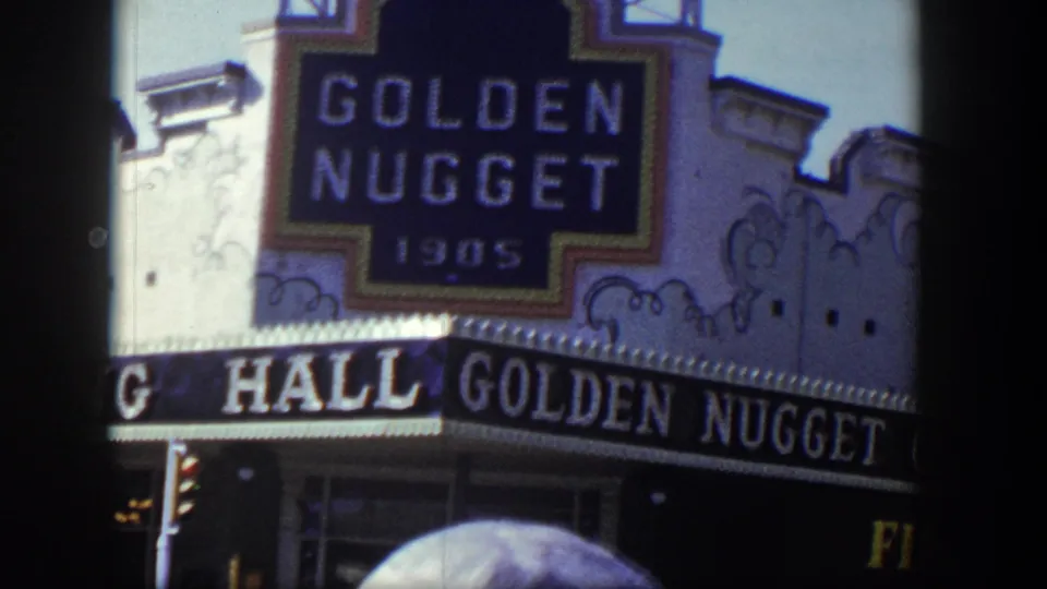 1954 Las Vegas view of the Golden Nugget marquee and Gambling Hall awning with a car roof crossing the lower frame.
