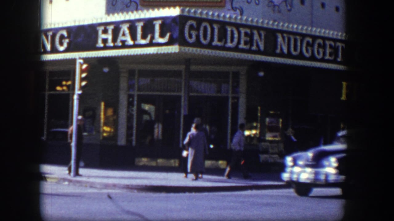 Golden Nugget marquee above a sidewalk with pedestrians and a passing car.