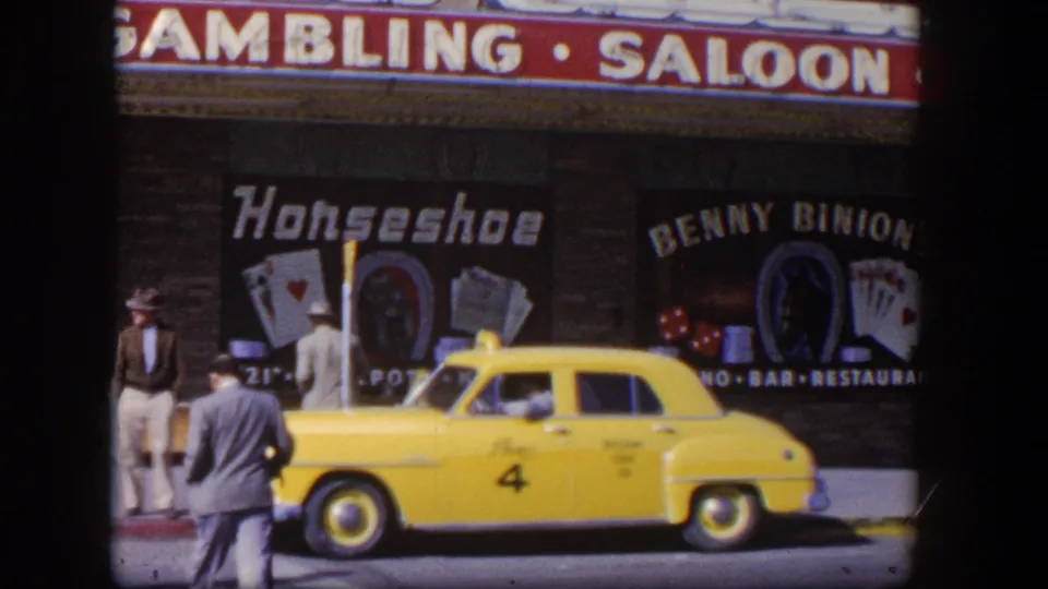 1954 Las Vegas sidewalk scene with suited men near a yellow taxi and prominent Horseshoe and Benny Binion's gambling signage.