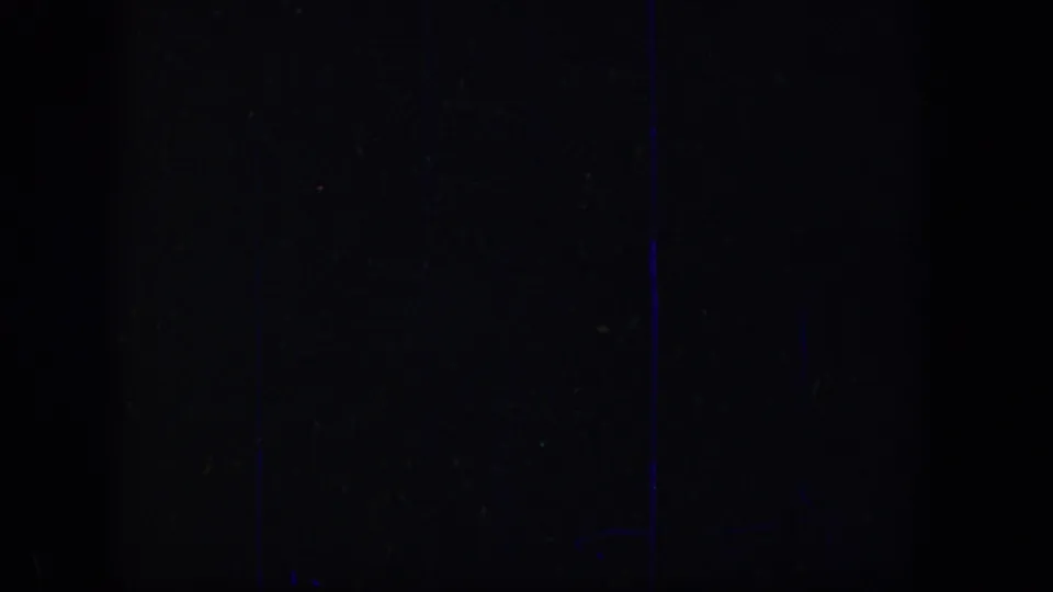 Dark 8mm frame section with minimal visible subject detail, likely between or obscuring adjacent street views.