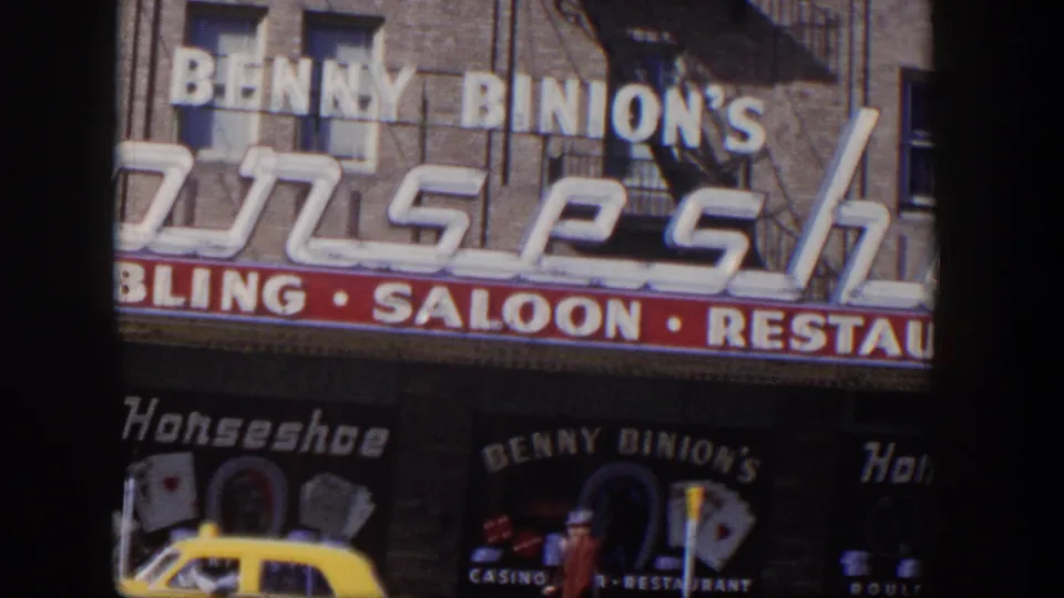 1954 Las Vegas storefront view showing Benny Binion's Horseshoe signage, casino entrance details, and a yellow taxi near the curb.