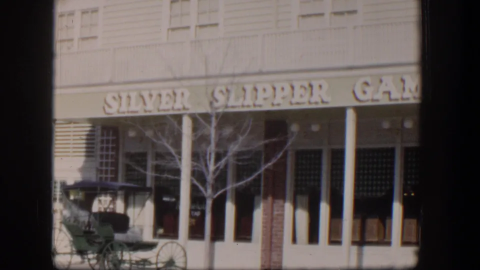 1954 Las Vegas exterior view of the Silver Slipper Gambling facade with a green carriage parked along the street.