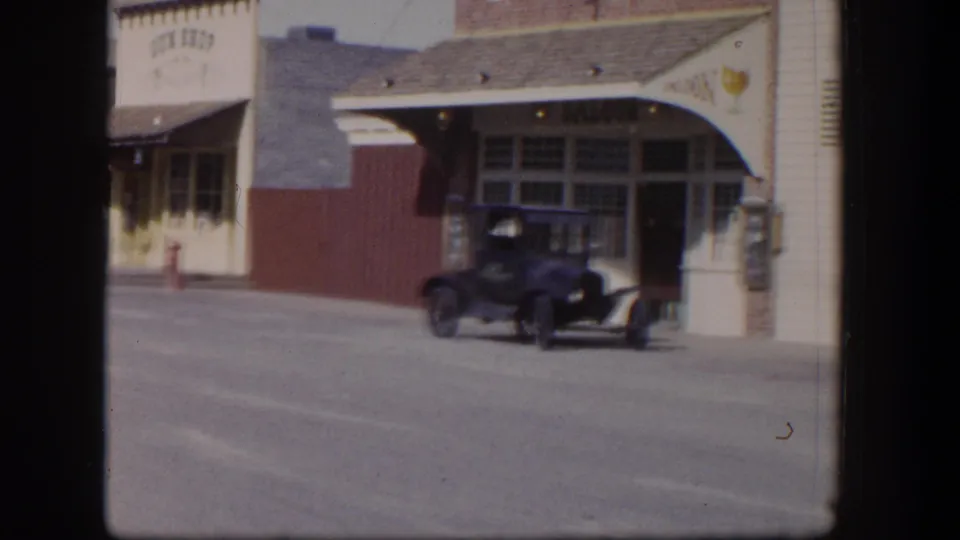 1954 Las Vegas storefront with an early automobile parked near a broad awning and large street-facing windows.