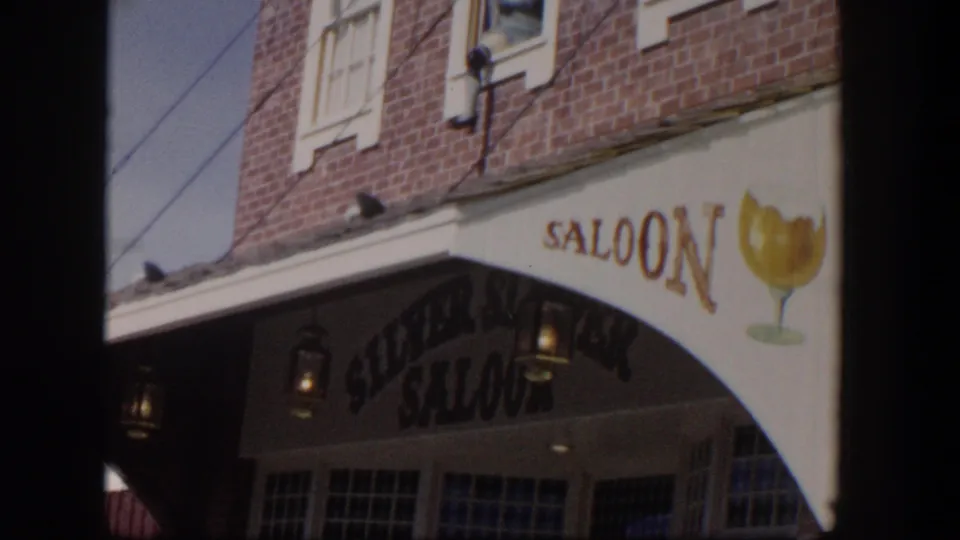 Las Vegas saloon exterior in 1954 with arched Silver Spoon Saloon entrance, lanterns, painted signage, and upper brick facade.