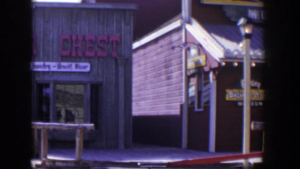 1954 Las Vegas frame with the Silver Chest shop at left and a neighboring wooden storefront edge coming into view during the pan.