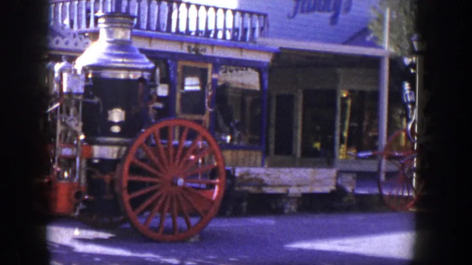 1954 Las Vegas frame with the fire engine centered, showing polished metal, red wheels, and a blue-trimmed facade behind it.