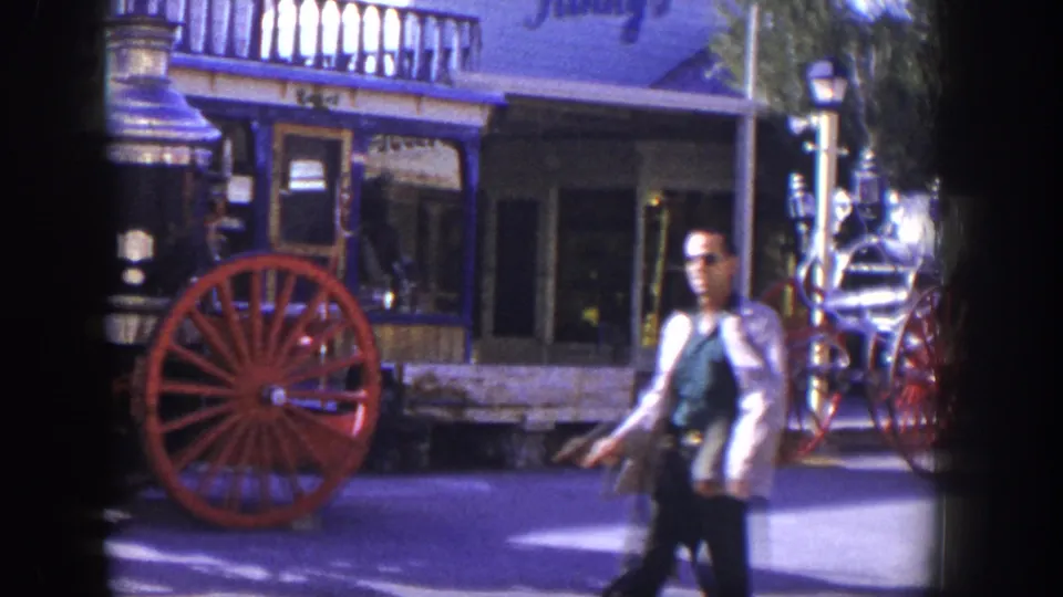 1954 Las Vegas home-movie frame showing a man walking across the foreground near the parked steam fire engine.