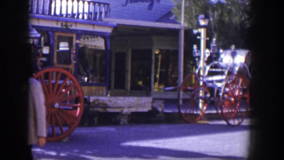 1954 Las Vegas frame with a partial pedestrian at left, the fire engine wheels, and storefront details in the background.