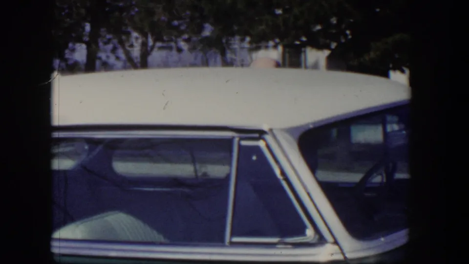 Close side view of the two-tone 1954 car, showing the white roof, rear side window, and chrome trim.