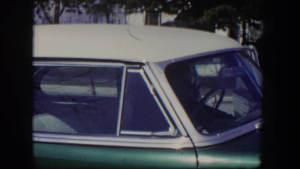 1954 Las Vegas frame with the sedan's front side glass, steering wheel, chrome trim, and white roof in view.