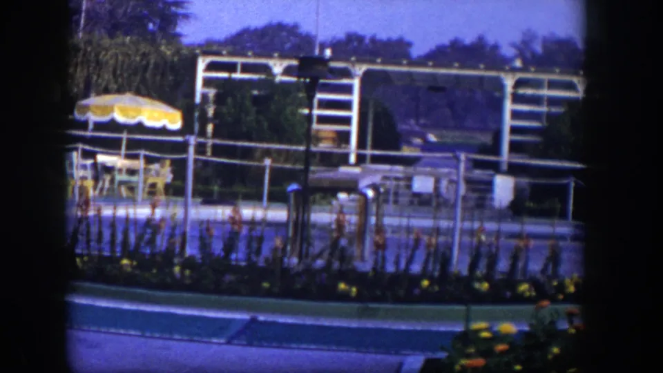 A later frame shows the Las Vegas resort setting without the woman, with yellow umbrellas, railings, planted beds, and a low building in view.