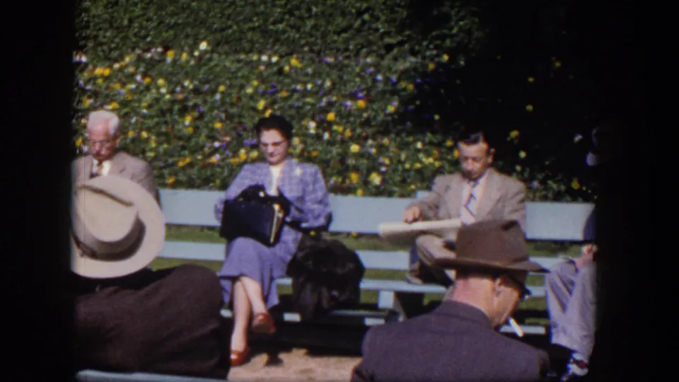 1954 Las Vegas park scene with adults on benches, including a woman reading and men in suits and hats in bright sun.