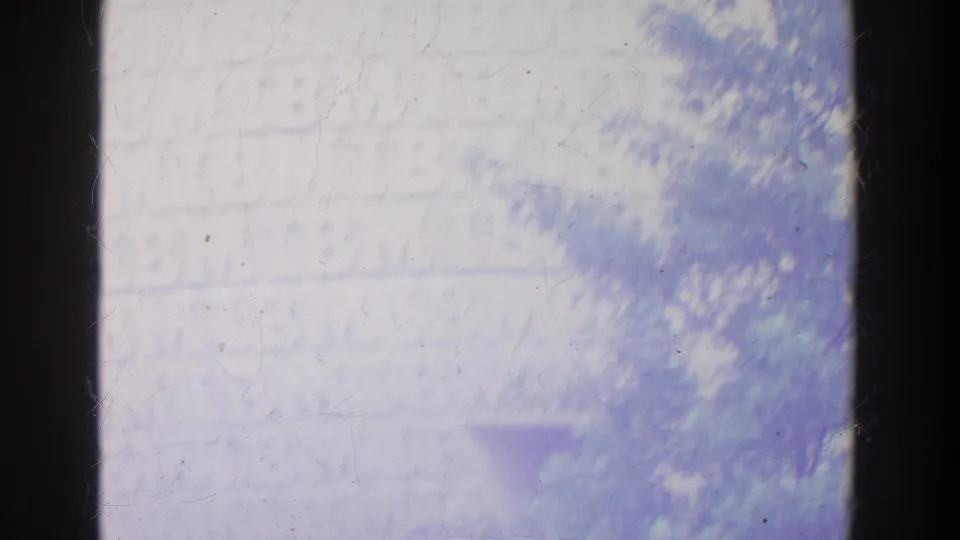 The final frame is mostly washed out, with a faint tram edge, pale background forms, and soft foliage-like texture at the right.