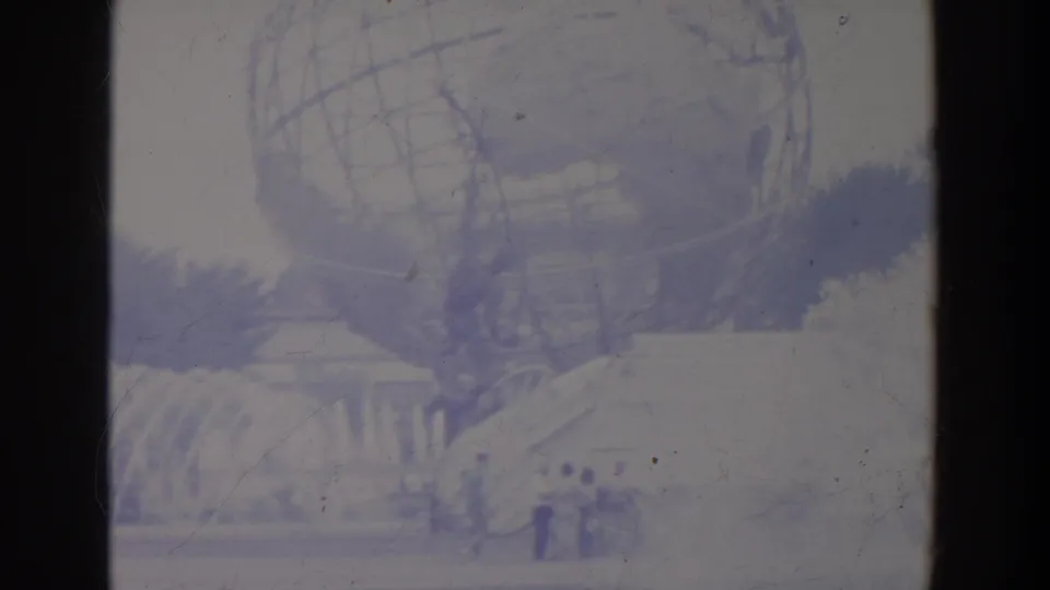The Unisphere appears above foreground fountain spray, with small groups of visitors moving through the fairground below.
