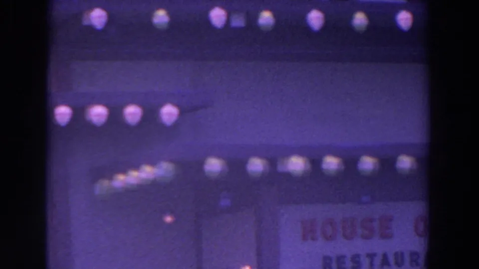 Nighttime 8mm view of the House of Japan area, with decorative globe lights and a partially visible sign on the right side.