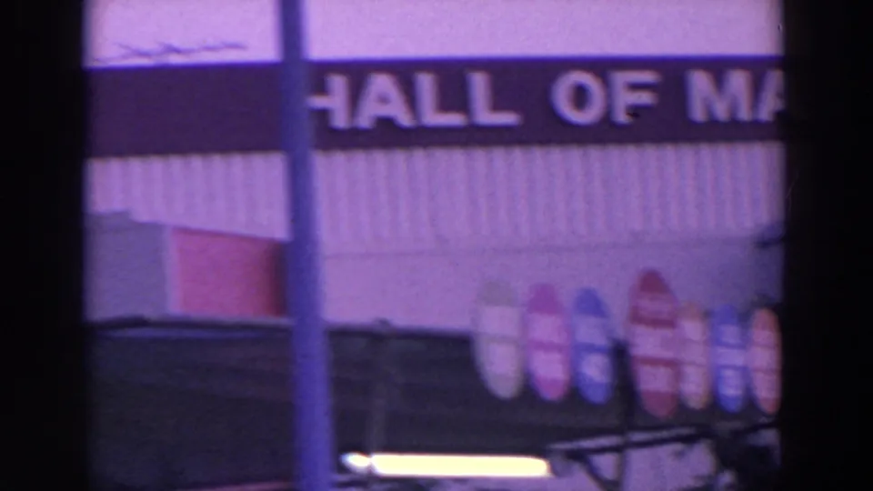 8mm view of Hall of Magic lettering beneath a Johnson sign, with colorful fairground display shapes at the bottom.