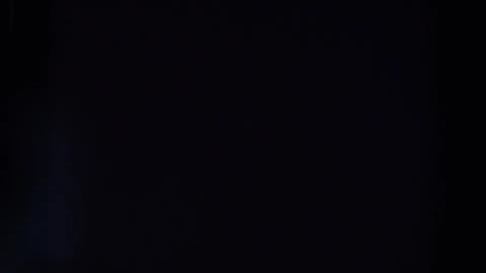 Underexposed final frame showing a barely visible vertical form in the darkness, consistent with handheld 8mm night footage.