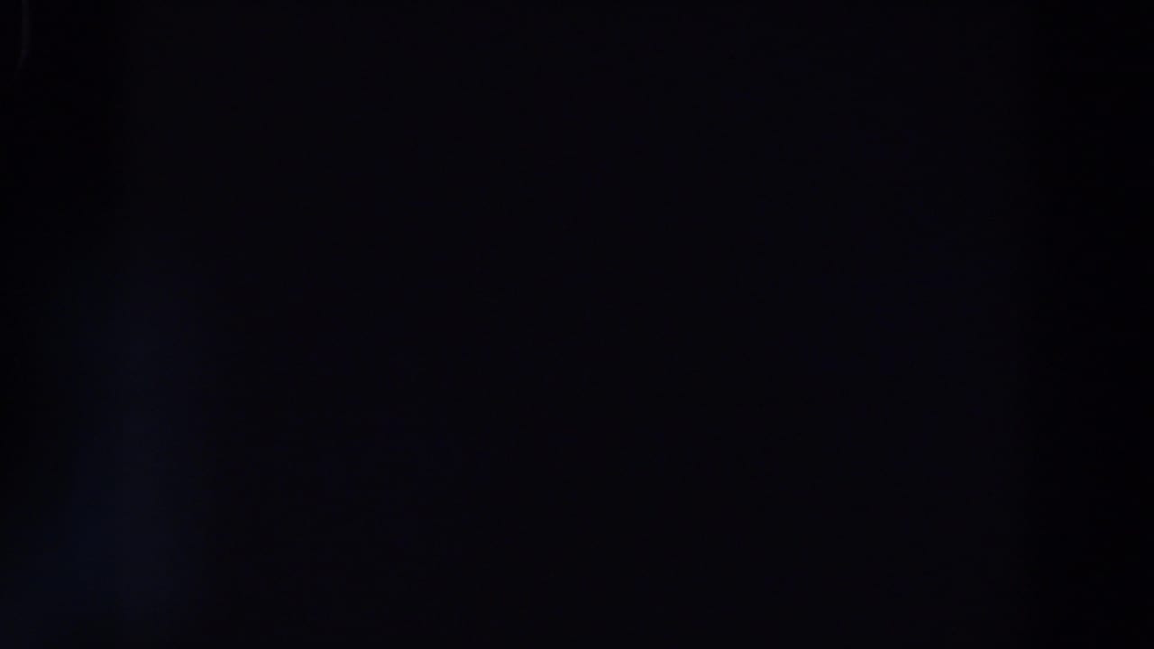 Nearly black frame with faint blue light and a dark horizontal band.