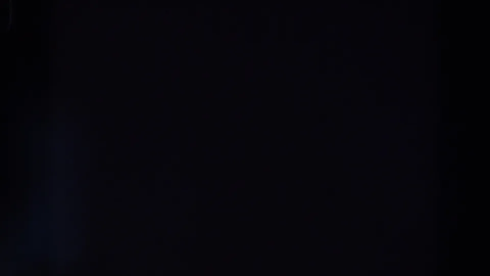 Underexposed 8mm frame from the supplied 1964 reel, showing mostly darkness with a faint blue glow and horizontal shadow band.