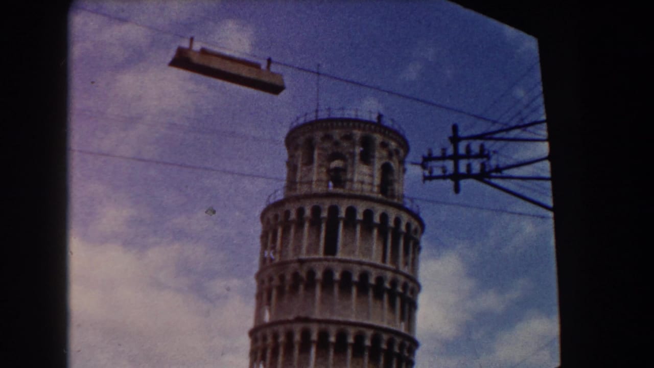 Leaning Tower of Pisa near the right side of frame with wires crossing the sky.