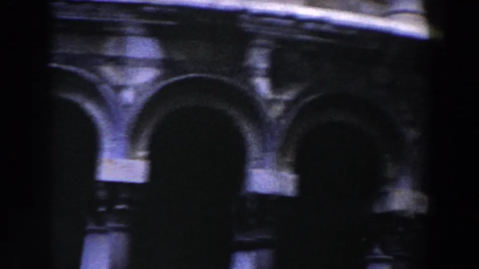 1959 Pisa home-movie frame showing a close, soft-focus view of the tower's arched exterior galleries.