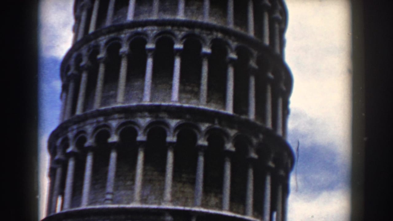 Upper section of the Leaning Tower of Pisa against a cloudy sky.