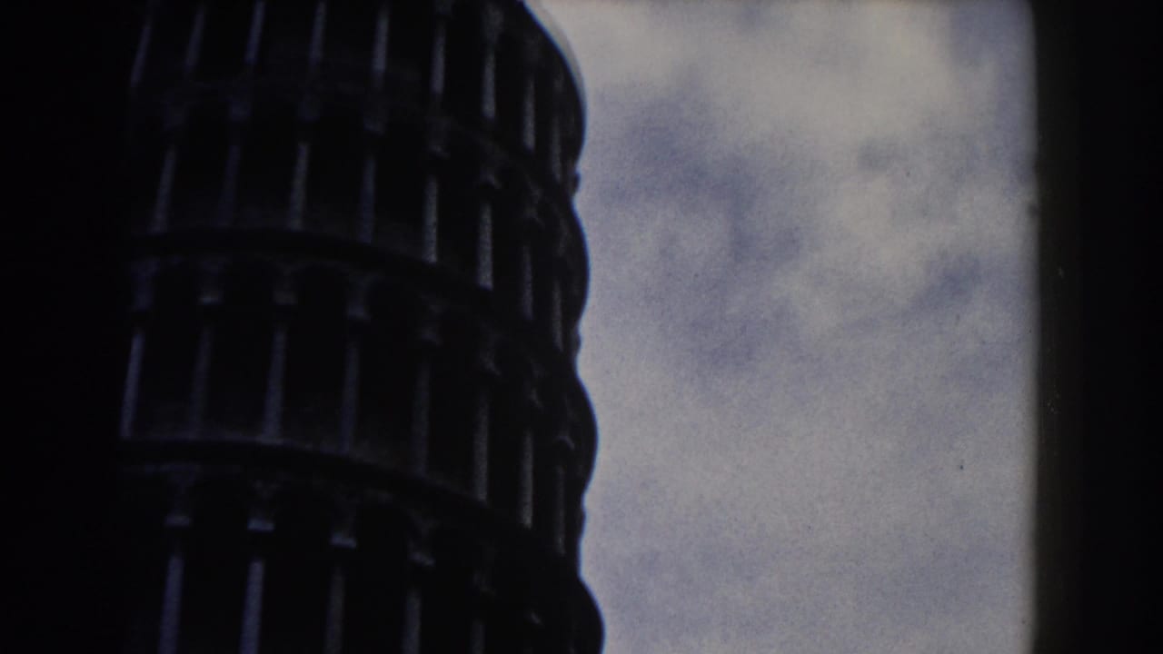 1959 Pisa footage showing the upper portion of the Leaning Tower framed tightly against a cloudy sky.