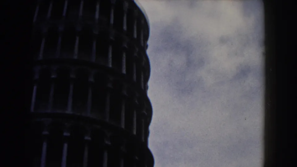 1959 Pisa footage showing the upper portion of the Leaning Tower framed tightly against a cloudy sky.